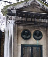 Grave marker with sculpture of heads of the dead couple