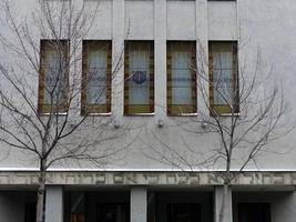 Building w. hebrew lettering above door, and menorah above