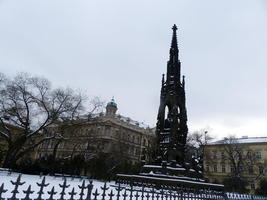 Spired sculpture in foreground, large building in background