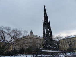 Spired sculpture in foreground, large building in background