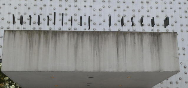 Seen from directly in front of entrance, only letter edges are visible.
