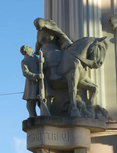 Sculpture of woman on horse. Standing next to her, a man with a rifle.