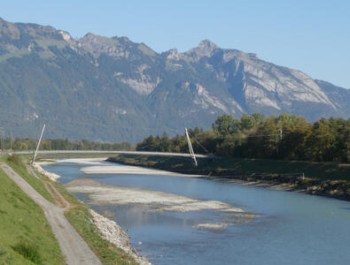 View across Rhine river, bridge in midground, mountains in background