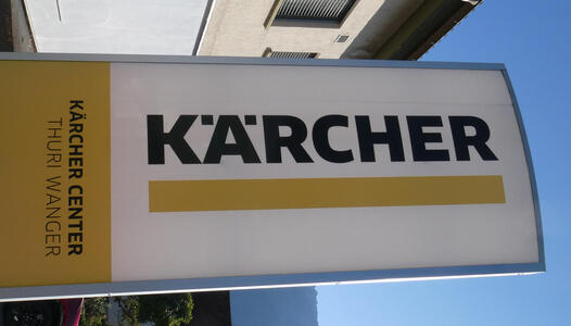 Sign with word KÄRCHER. The umlaut is one dot at left and right side of the A rather than atop it.
