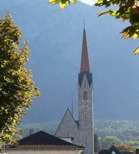 Churched framed by tree at left and upper right. The clock is visible on the church tower.