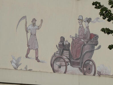 Wall painting. A farmer with a scythe is waving to a man and woman in early 1900s style clothing in an automobile