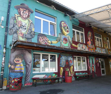 At left, man with hat and t-shirt with skull on it. In middle, a woman with a robotic head, at right, another woman.