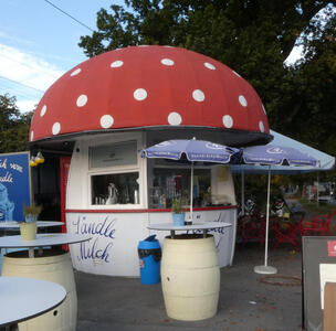 Snack stand in shape of a mushroom with a red cap with white dots