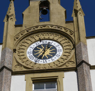 Clock face on church. In center of dial, a sun