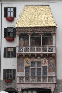 Small roof over a balcony; roof has gold-leaf shingles.