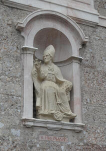 Stone carving of a seated man wearing a bishop’s mitre.