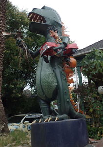 Godzilla holding car with terrified man in it