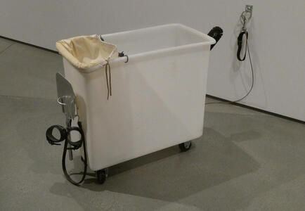 bin with handcuffs and leash attached