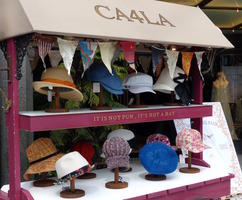 Hats on display with sign reading “It is not fun, it's not a hat.”