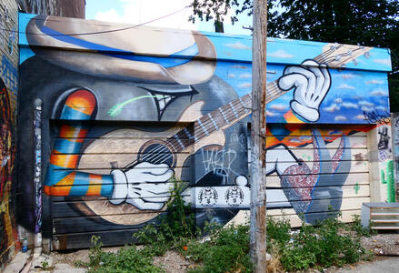 reclining person in hat playing guitar