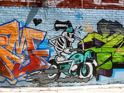skeleton in top hat riding motorcycle