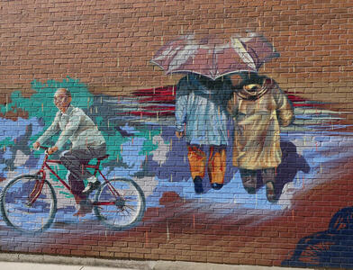 man on bicycle couple with umbrella