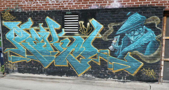 man in beret with spray paint