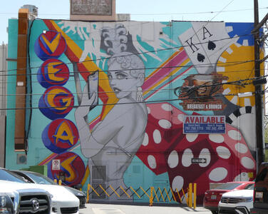 Wall mural; word VEGAS vertically at left, showgil in middle, dice, chips, and King and Ace cards at right