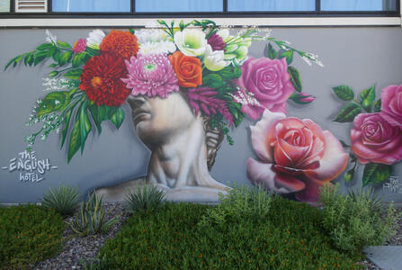Roman sculpture head with eyes obscured by bouquet of flowers