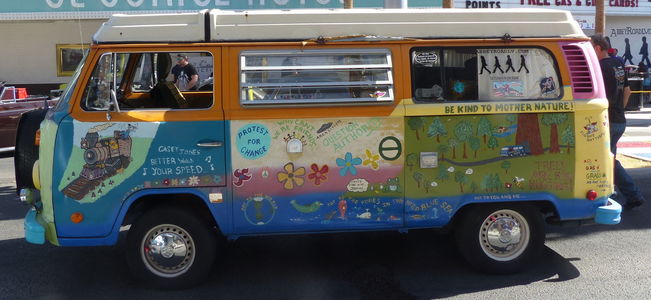 Driver side view of VW van with 60s slogans