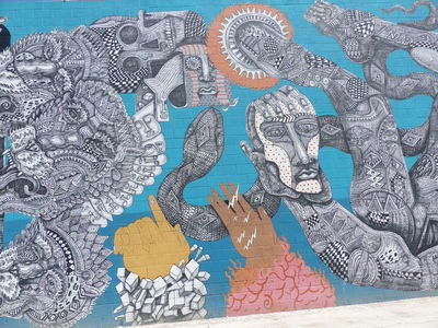 Hands pointing upwards; snake behind man's hand with face on it