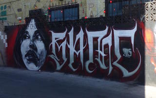 Wall art of woman's face and large lettering in a gothic style.