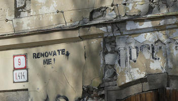 Crumbling building with stencil: Renovate me!