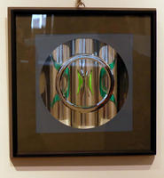 Steel ring in front of glass tubes with green glass